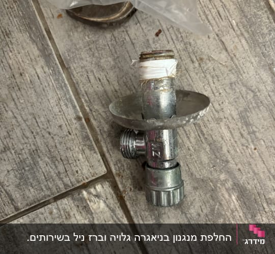 שסתום מתכת עם סרט טפלון על רצפה